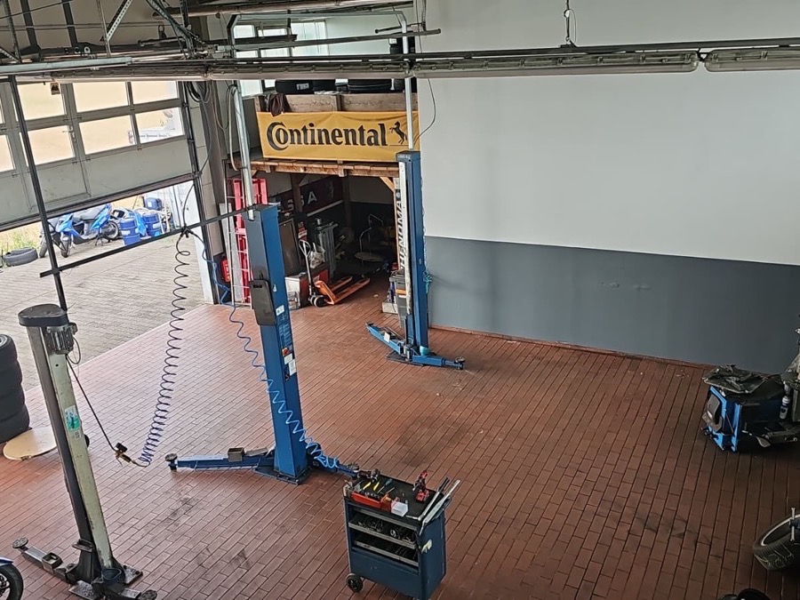 Werkstatthalle mit Hebebühne, Reifenmontiermaschine und Werkzeugwagen